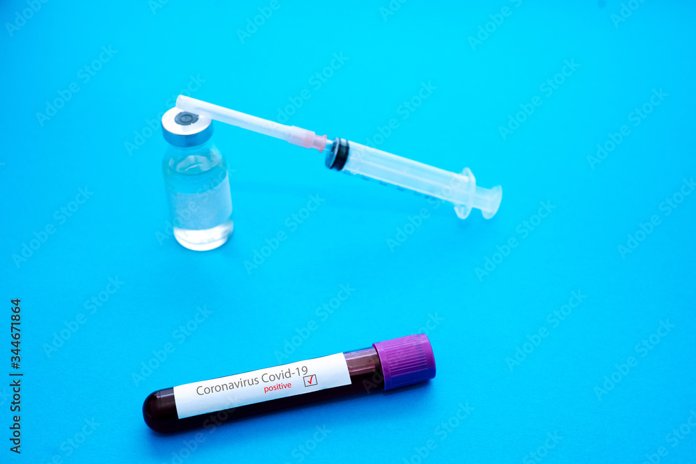 Coronavirus Covid-19 outbreaking. Medicine and epidemic concept. Tube with positive blood test result, protective face mask, medication pills, stethoscope, vial and syringe, vaccine in laboratory Coronavirus Covid-19 outbreaking. Medicine and epidemic concept. Tube with positive blood test result, protective face mask, medication pills, stethoscope, vial and syringe, vaccine in laboratory