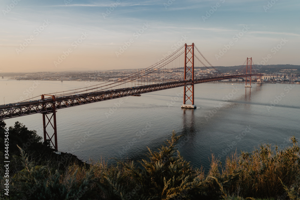 '25 of April' Bridge over tagus river at sunset in Lisbon, Portugal. View from Sanctuary of Christ the King 'Cristo Rei'