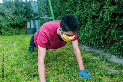 Teenager does exercise with mask and gloves during a pandemic. COVID-19. Health care.