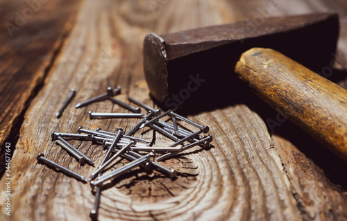 old hammer with nails on a wooden table, home repair concept