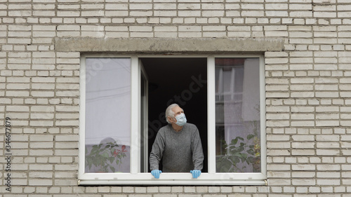 Old man grandfather stay at window isolated at home on quarantine. Coronavirus © Andrii Iemelianenko