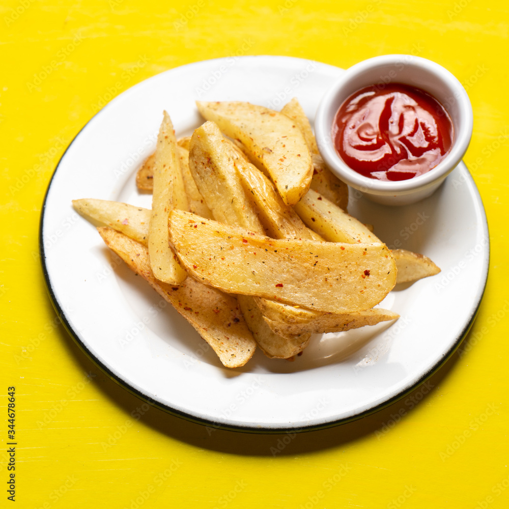 French fries with ketchup sauce on yellow background French fries with ketchup sauce on yellow background