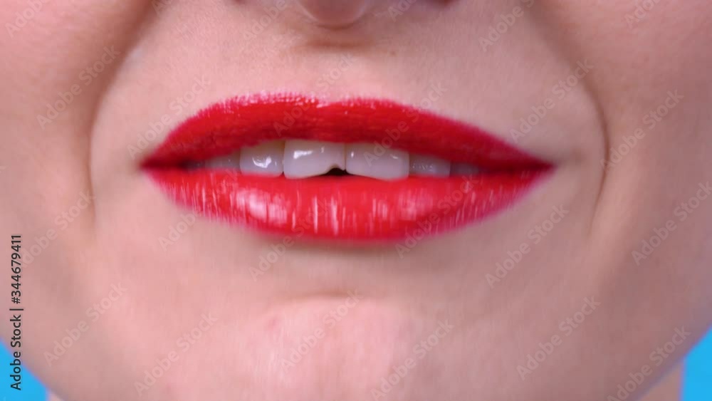Young girl with bright red shiny lipstick on her sexy lips pronounces the phrases I LOVE YOU, FUCK YOU, I LOVE APPLE, close up. Young girl with bright red shiny lipstick on her sexy lips pronounces the phrases I LOVE YOU, FUCK YOU, I LOVE APPLE, close up.