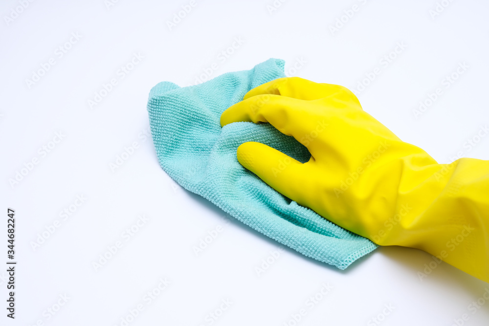 Hand in yellow rubber glove wiping dust with microfiber cloth, cleaning up the house concept, white background Hand in yellow rubber glove wiping dust with microfiber cloth, cleaning up the house concept, white background