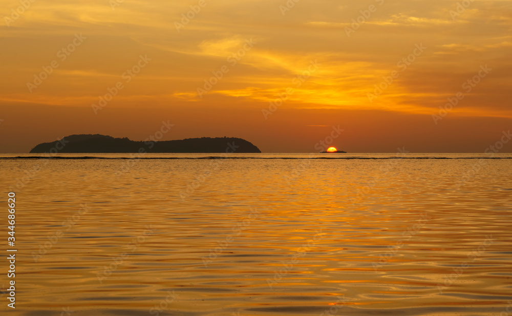 Famous rhun island and golden sun going down into the horizon seen from pulau Ai island, Banda, Maluku, Indonesia