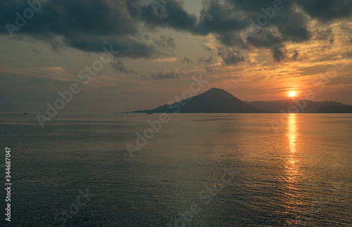 Api volcano mountain and sunset or sunrise with long sunbeam over the banda sea