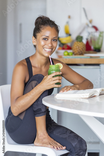 Latin woman staying healthy at home having a green juice