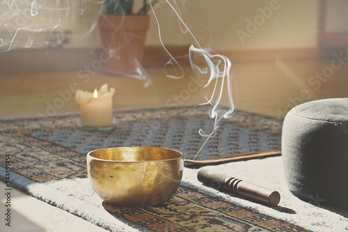 meditation room with singing bowl, incense stick, smoke, pillow and candle