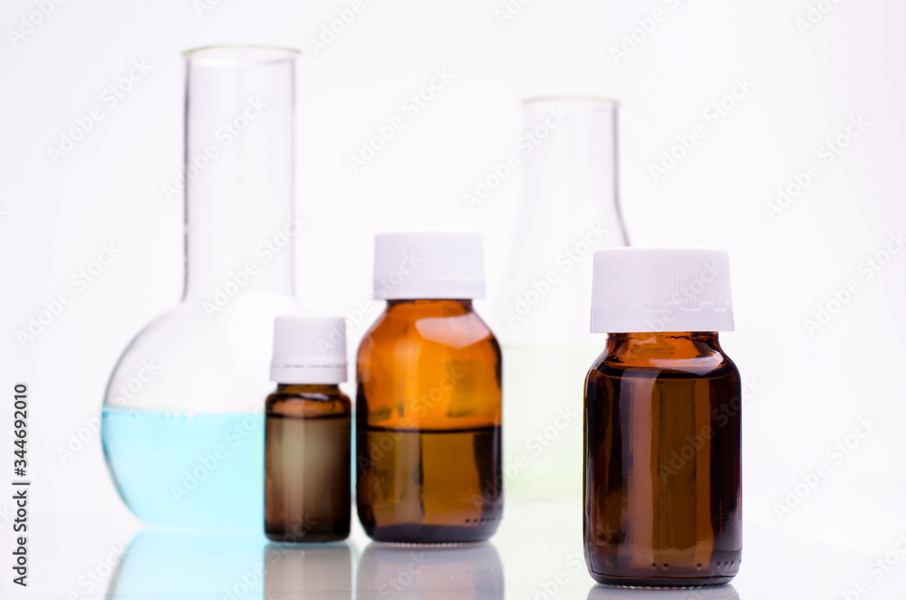 Medicine bottle and laboratory flasks against white background. Medicine bottle and laboratory flasks against white background.