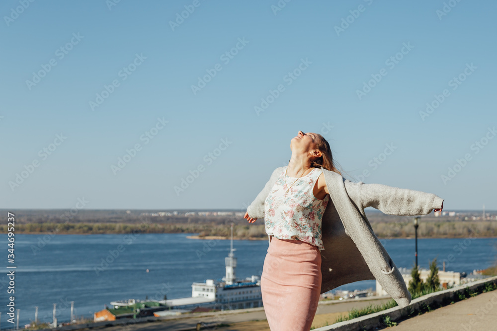 Portrait of smiling woman in a white cardigan. Laughing girl on the background of street, freedom and happiness Portrait of smiling woman in a white cardigan. Laughing girl on the background of street, freedom and happiness