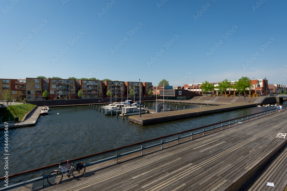 Almere, Netherlands - April 22 2019: Yacht marina in Almere, bordered by a modern pedestrian bridge