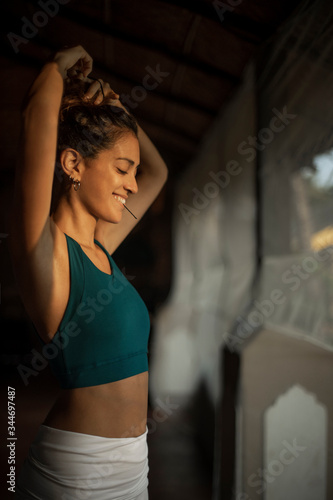 The young woman fixing hair between yoga practice