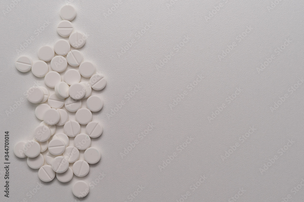 White tablets scattered on a white background White tablets scattered on a white background