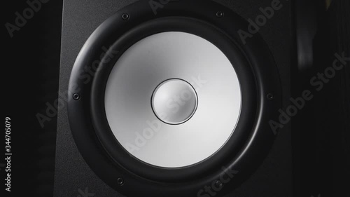 Close up of moving modern sub-woofer on recording studio. White round audio speaker pulsating and vibrating from sound on low frequency. Work of high fidelity loudspeaker membrane. Slow motion photo