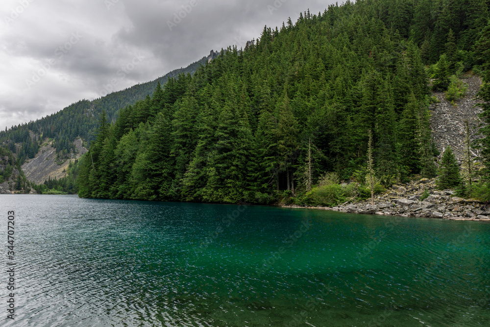 Beautiful mountain Lindeman lake green forest and cloudy sky british columbia canada.