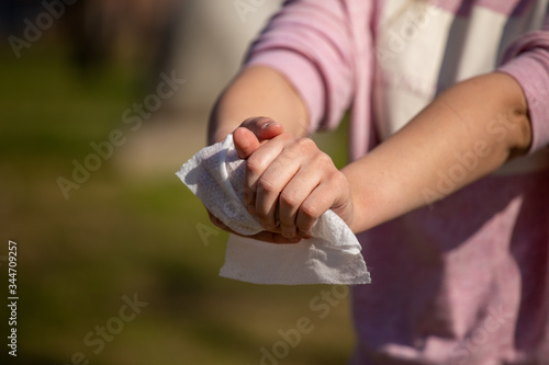 Cleaning hands with wet wipes against disease infection like flu or influenza
