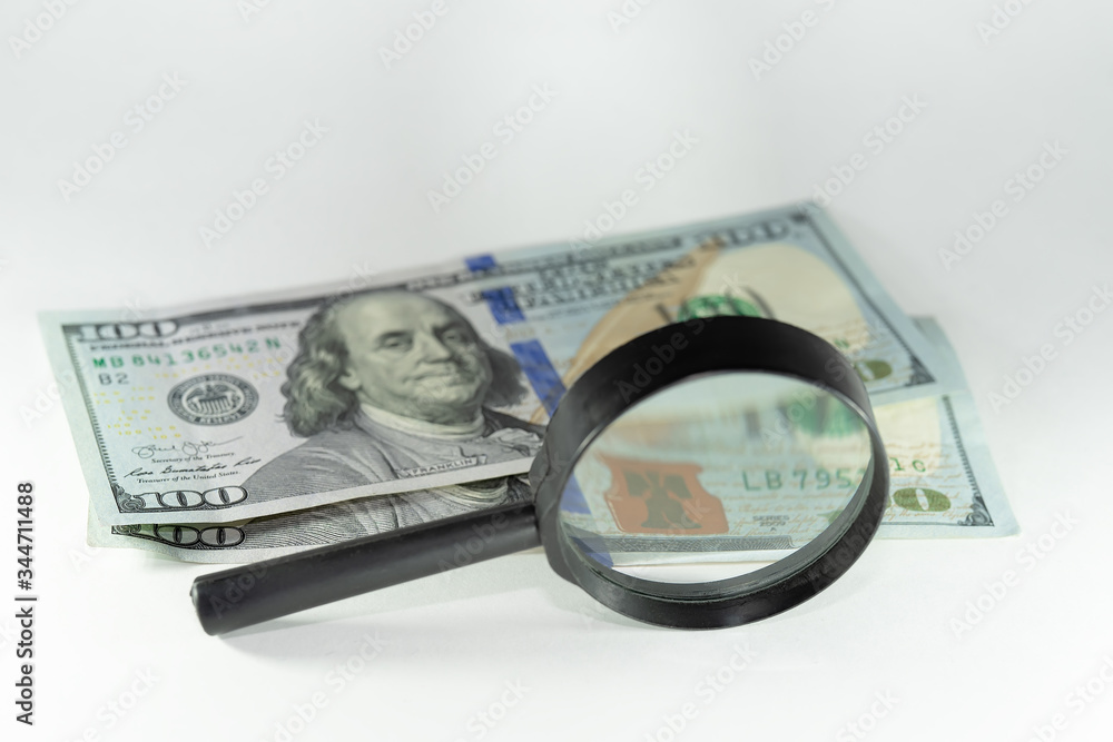 money dollars and euros through a magnifier. On white background money dollars and euros through a magnifier. On white background