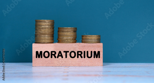 MORATORIUM text with stack coin on green background. Business and economic concept