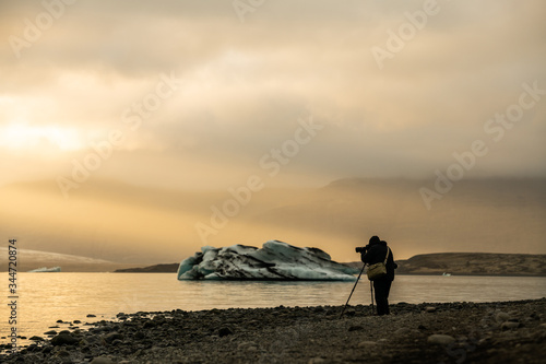 Photographer shooting icebergs in Jokulsarlon glacier lagoon during sunset time