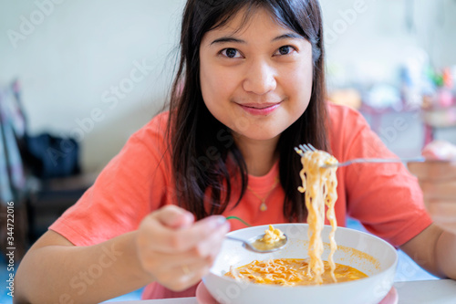 Asian woman eating instant noodles is happy to eat