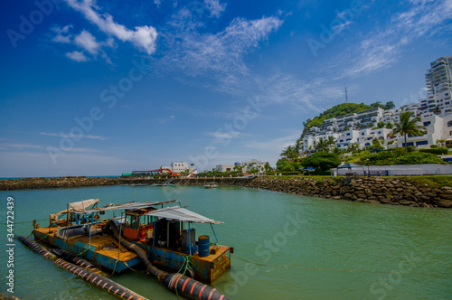 MANABI, ECUADOR - JUNE 4, 2012: Close up of a water pumping machine in a stagnant water with a at Same, Ecuador in a beautiful blue sky in a sunny day photo