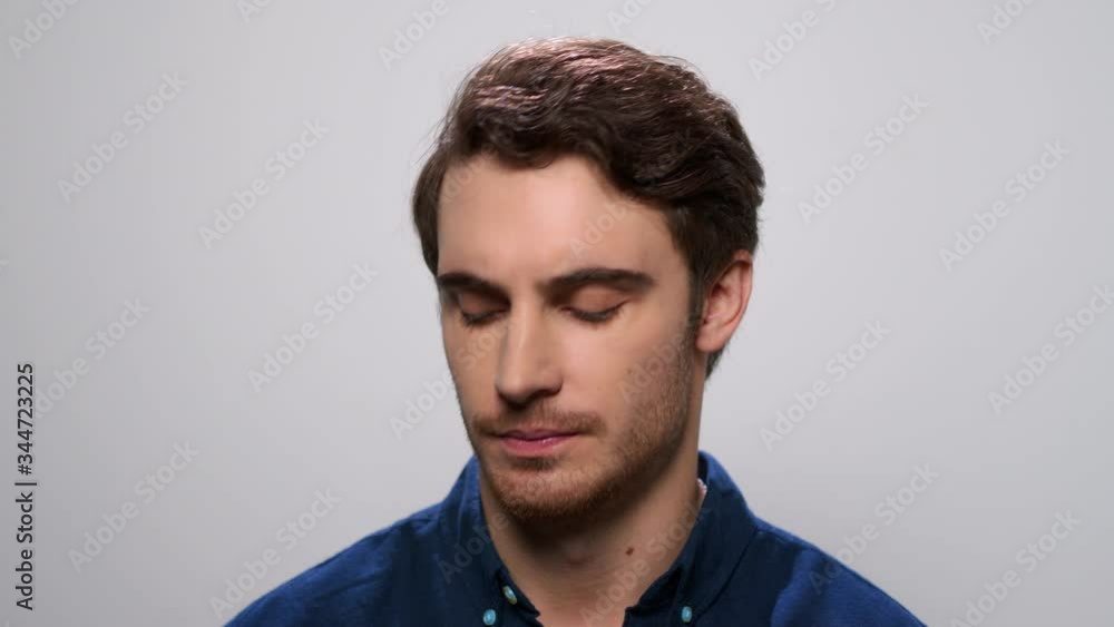 Smiling man dancing in studio. Male model biting lips on light background Smiling man dancing in studio. Male model biting lips on light background