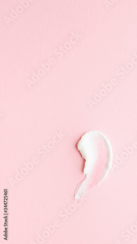 White smear and texture made by cream isolated on pink background.