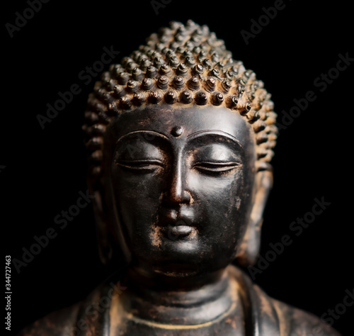 Wallpaper Mural A small replica statue of the head of The Buddha isolated on black Torontodigital.ca