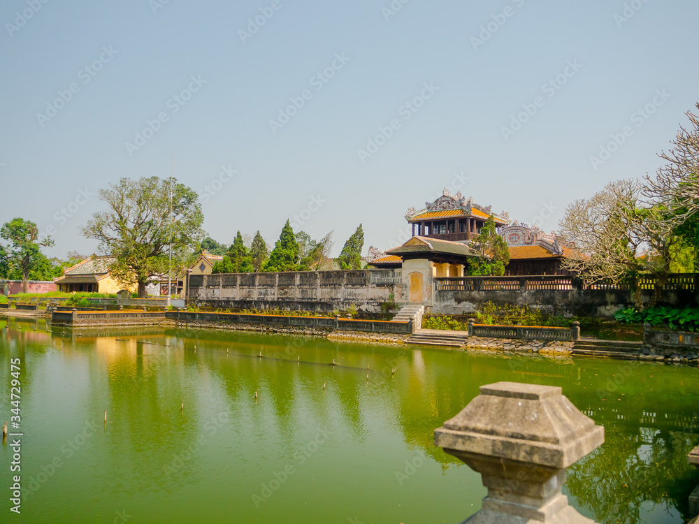 Hue, Vietnam - September 13 2017: Close up of old beautiful temple, with an artifical pond in front, reflected in the water, located in Hue city, Vietnam Hue, Vietnam - September 13 2017: Close up of old beautiful temple, with an artifical pond in front, reflected in the water, located in Hue city, Vietnam