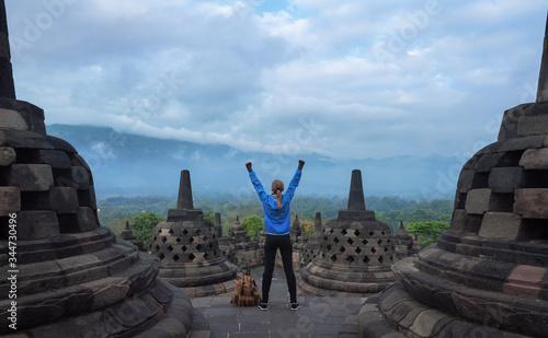 Woman in running shoes rising hands then exploring the Borobudur temple in Java island  Indonesia