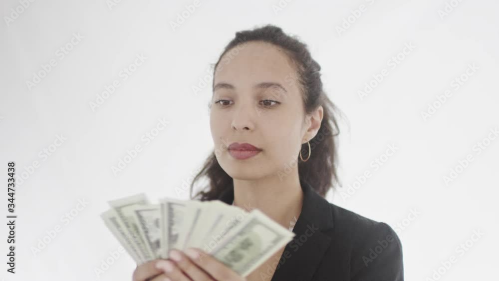 Serious dark-haired busensswoman with ponytail looks with satisfaction at pack of dollars in her hands counting. 4K 360 degree tracking arc shot. Serious dark-haired busensswoman with ponytail looks with satisfaction at pack of dollars in her hands counting. 4K 360 degree tracking arc shot.