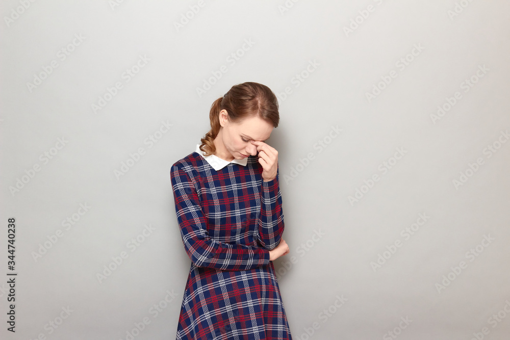 Portrait of thoughtful tired young woman touching bridge of her nose Portrait of thoughtful tired young woman touching bridge of her nose