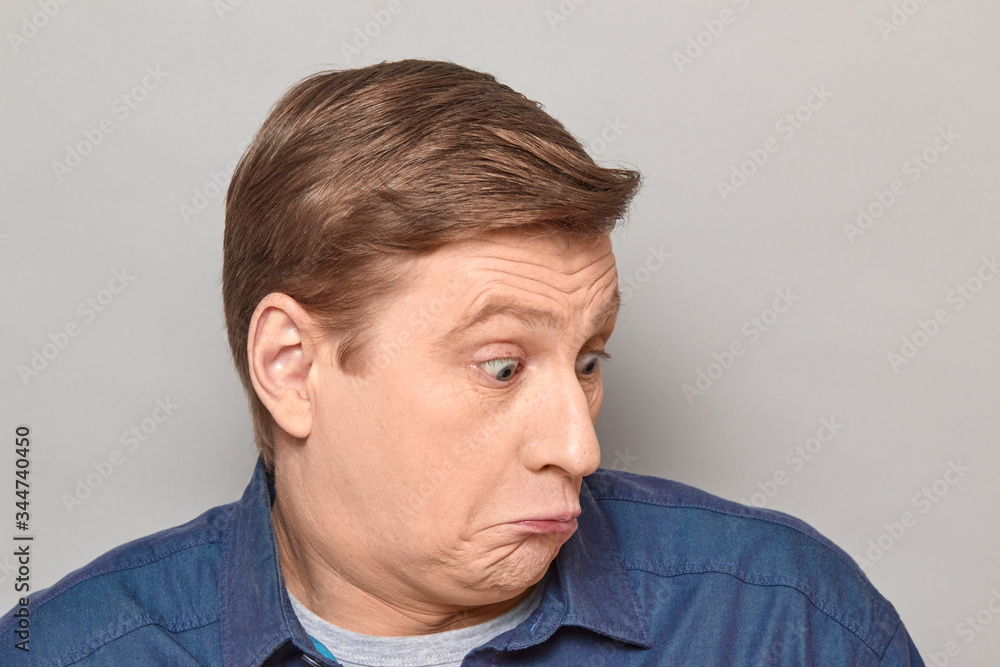 Obraz premium Portrait of blond mature man with silly perplexed expression on face