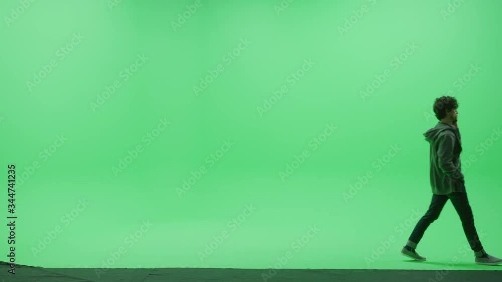 Green Screen Chroma Key Studio: Strong Man Wearing Casual Clothes, Uses Smartphone, Talking on the Mobile Phone, Dealing With business, talking to a Girlfriend Walks Across Room. Side View Camera Shot Green Screen Chroma Key Studio: Strong Man Wearing Casual Clothes, Uses Smartphone, Talking on the Mobile Phone, Dealing With business, talking to a Girlfriend Walks Across Room. Side View Camera Shot