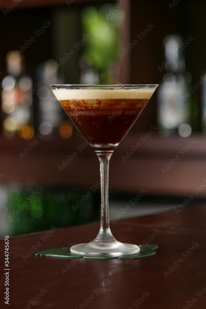 A glass of classic espresso martini on the bar counter A glass of classic espresso martini on the bar counter