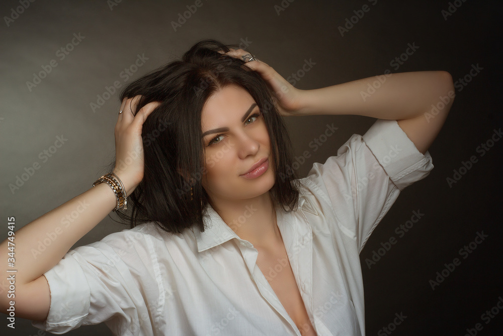 brunette in a white blouse on a dark background. Long straight hair