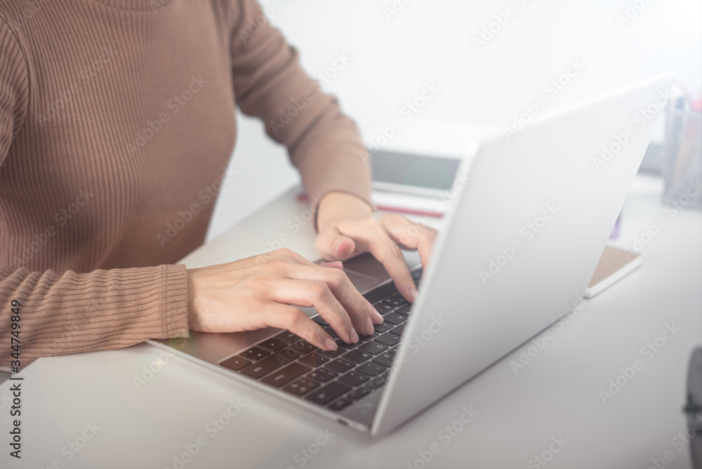 Naklejka premium business woman working on white desk with laptop, pad, smartphone at office look very busy. work from home concept
