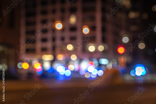 An out of focus cityscape background image of Michigan Avenue in downtown Chicago with red and blue police and ambulance lights at a street corner responding to an emergency blurred in background.