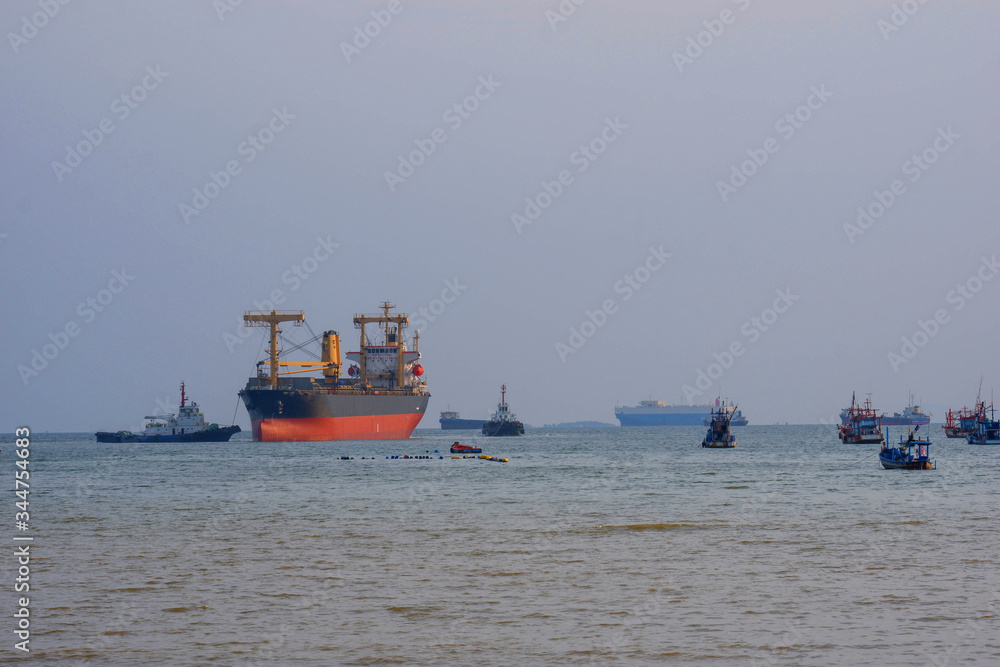 Large vessels carrying goods and fishing boats in the middle of the sea
