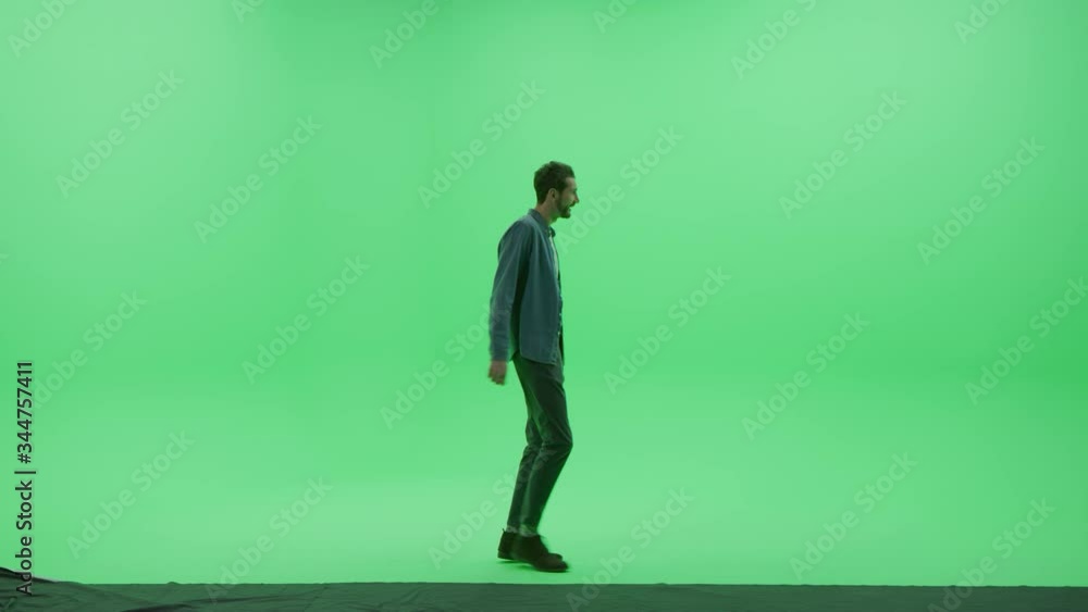 Green Screen Chroma Key Studio: Strong Handsome Smiling Man Wearing Casual Clothes Dances Across Room Left to Right. Side View Camera Shot Green Screen Chroma Key Studio: Strong Handsome Smiling Man Wearing Casual Clothes Dances Across Room Left to Right. Side View Camera Shot