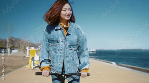 Young asian woman in a jeans jacket rides the scooter near the river photo