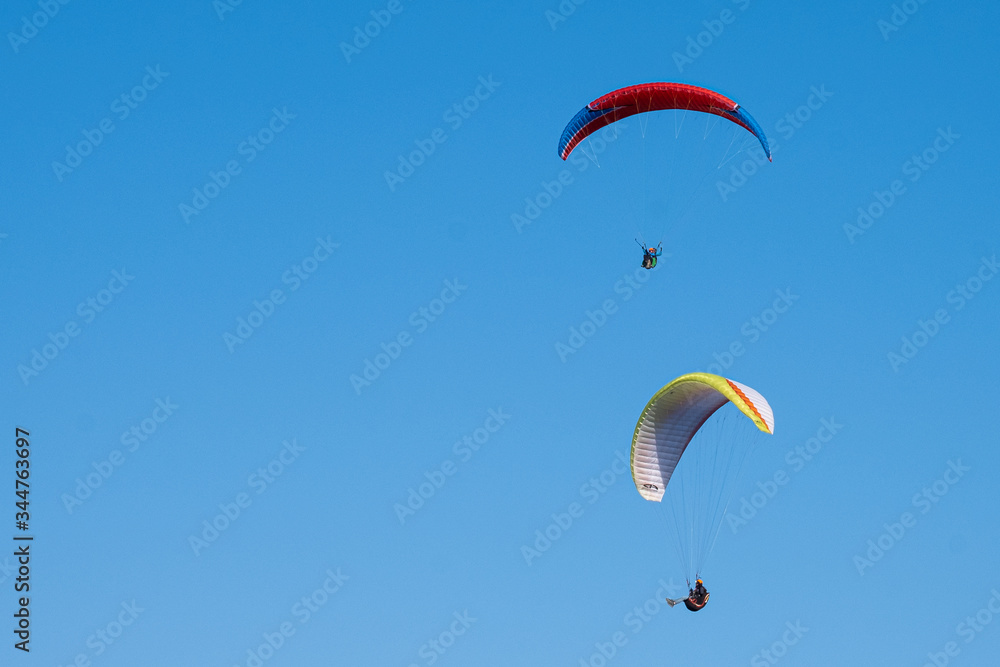 Paraglider in the sky. Parachute. Pilot. Free fall. Blue sky Paraglider in the sky. Parachute. Pilot. Free fall. Blue sky