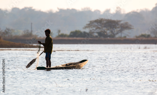  fisherman on canoe in tropical Bungva lake, Laos