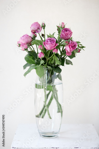 A vase filled with purple rose peony flowers