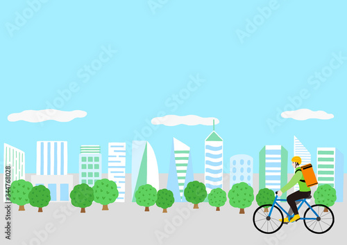 自転車に乗っている配達員の男性と高層ビル群の風景　出前　デリバリー　宅食
