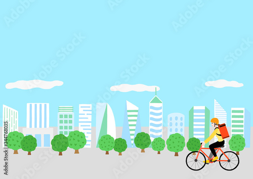 自転車に乗っている配達員の女性と高層ビル群の風景　出前　デリバリー　宅食