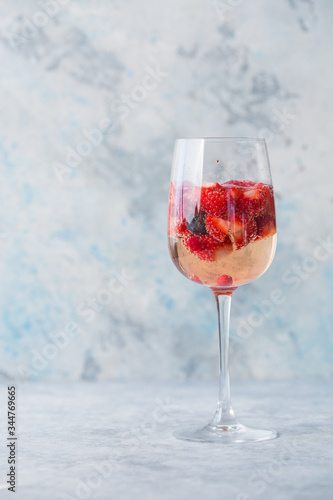 Glass with ice Summer homemade Cold red sangria cocktail with strawberry  in glass on blue  background. Concept of vacation  summer