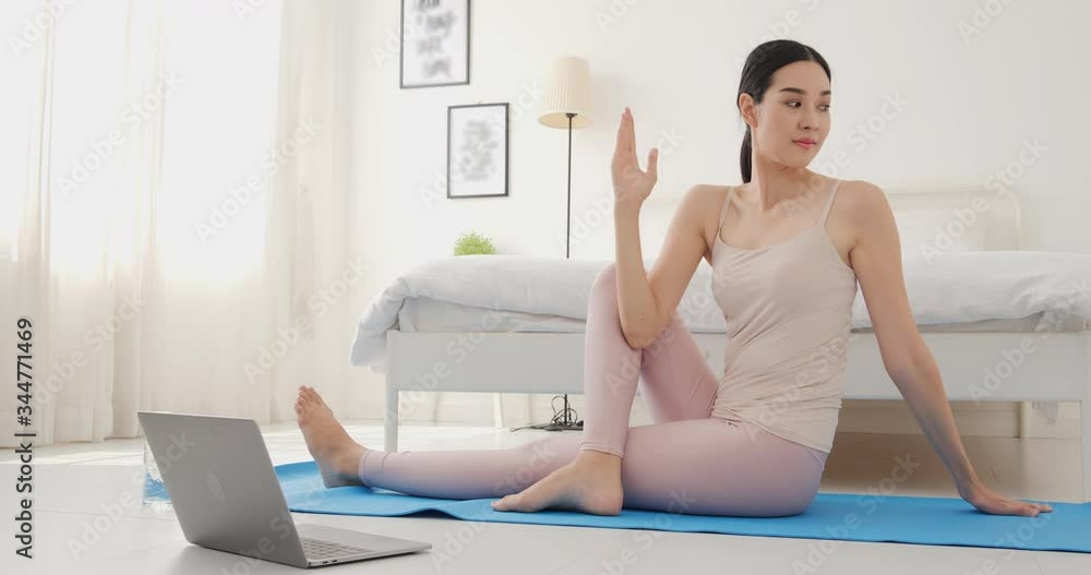 Asian woman using laptop to practice yoga at home. She training yoga online class at her room in morning. Healthcare and Sport concept. Asian woman using laptop to practice yoga at home. She training yoga online class at her room in morning. Healthcare and Sport concept.