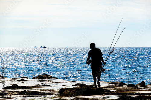 【シルエット】岩場で釣りを楽しむ男性