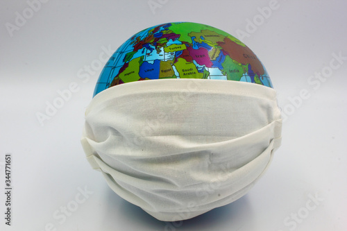 world earth globe focused on europe africa and asia with medical surgical face mask to combat corona virus covid 19